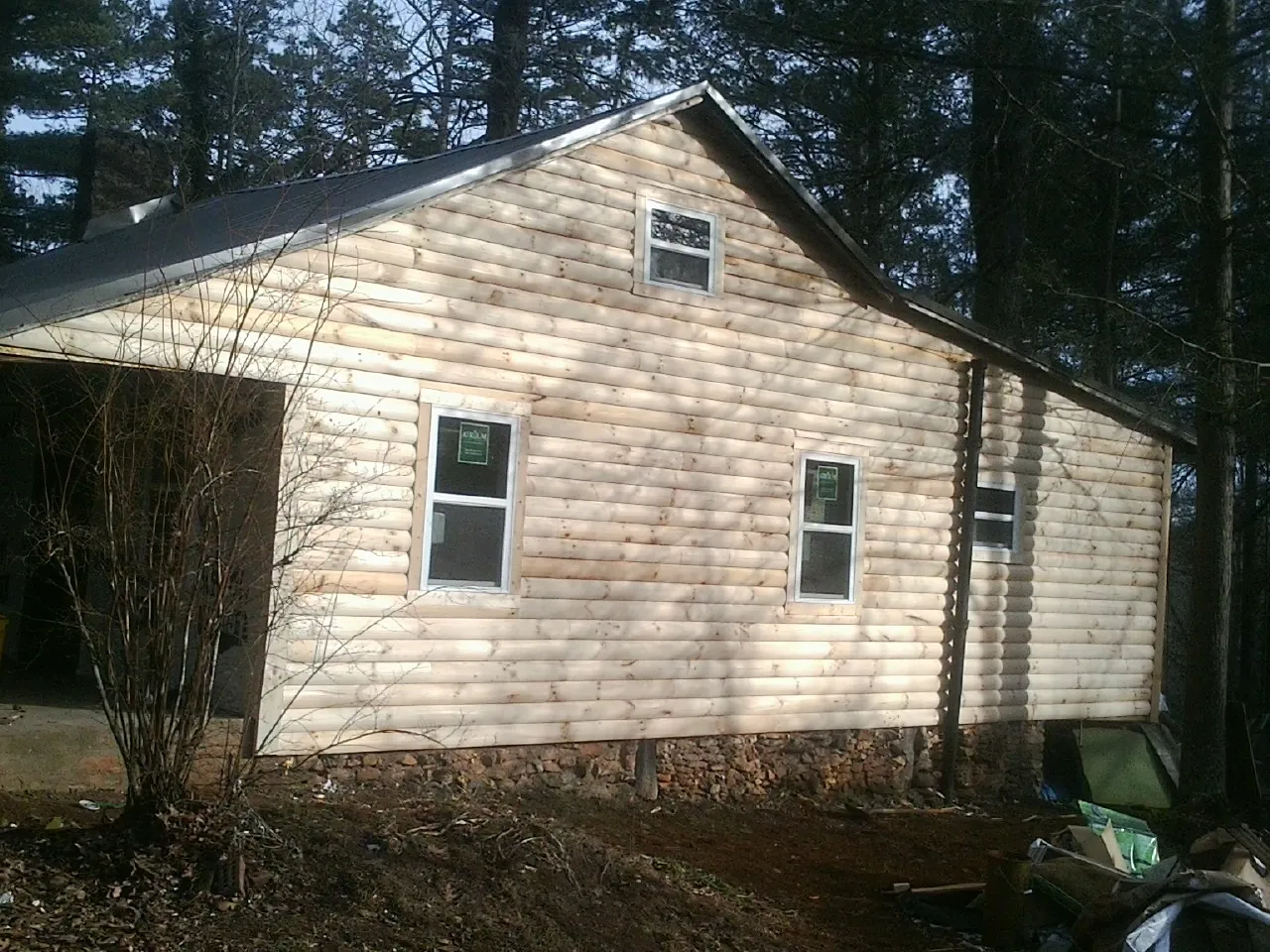 New log siding and dark metal roofing on a gable end in Warsaw